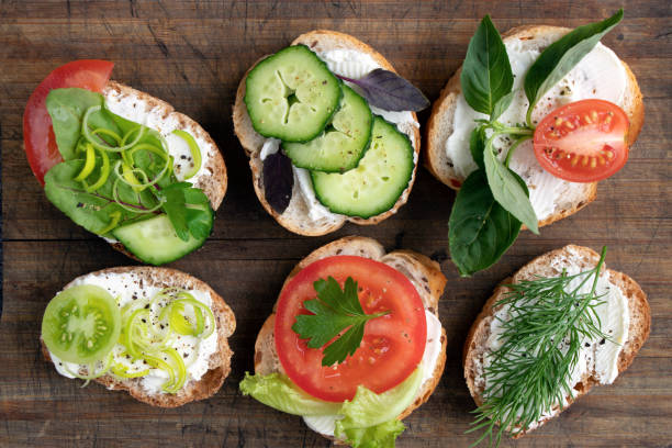istock various vegetable sandwiches with cream cheese, tomatoes, dill, cucumbers, leeks and basil. serving a vegetarian sandwiches for appetizers on cutting board. top view 1326109472