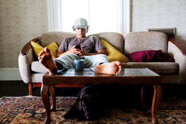 A teenaged boy using his phone at home