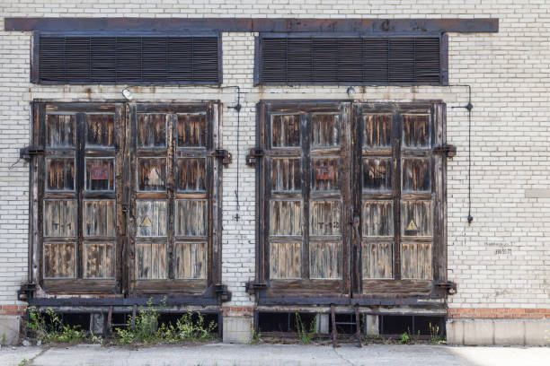 istock Large old wooden doors in a brick building for servicing electrical communications. 1326111244