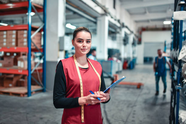 istock Cute Female Textile Worker Taking Charge Of Warehouse Shipments With Clipboard 1326112372