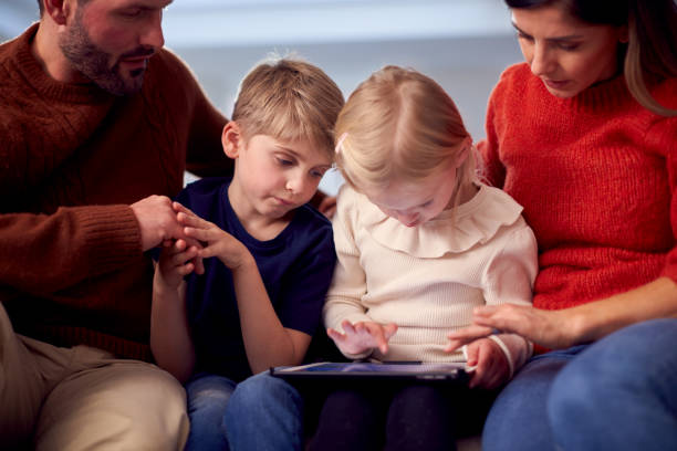 istock Family Sitting On Sofa Watching Digital Tablet Together 1326113681