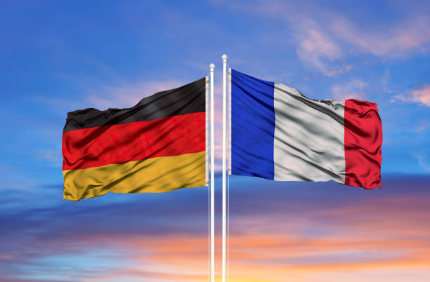 germania e francia due bandiere sui pali delle bandiere e cielo nuvoloso blu - pleasance foto e immagini stock