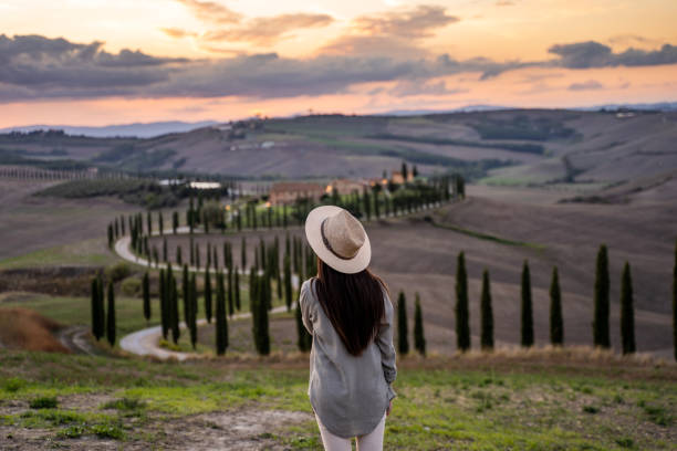 istock Woman standing on a hill watching the sunset 1326115408