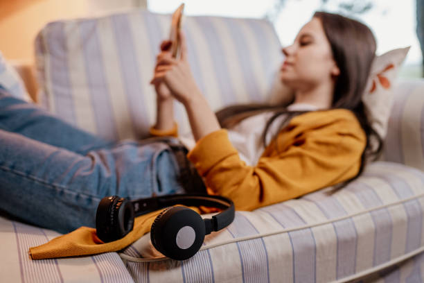 istock Woman using phone on sofa in living room 1326115803
