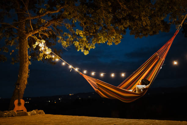 Woman sleeping in a hammock at night