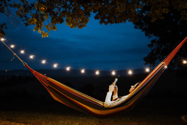 istock Young woman relaxing in a hammock and using smartphone 1326115918