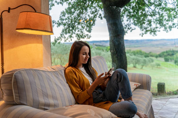 istock Girl sitting on the couch and using mobile phone 1326116672