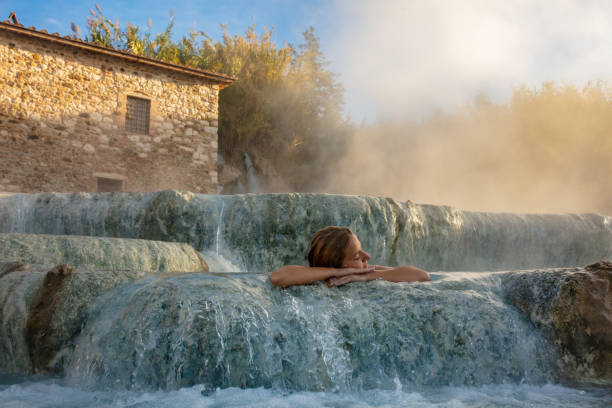 istock Woman relaxing in natural spa and waterfall 1326117364