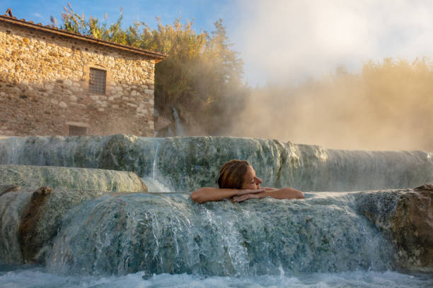 woman relaxing in natural spa and waterfall - waterfall health spa man made landscape imagens e fotografias de stock