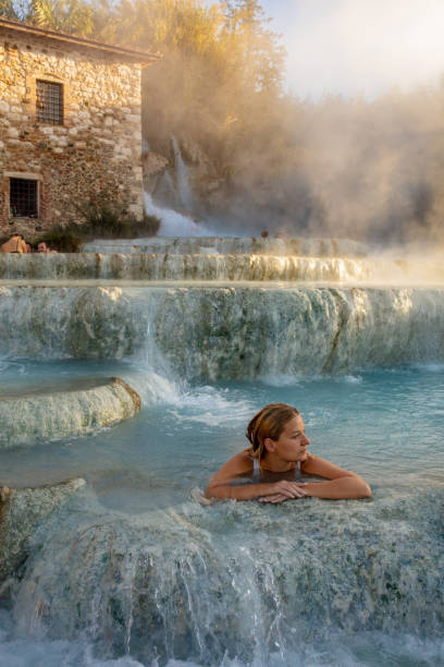 mulher bonita tomando banho em spa natural, saturnia, toscana, itália - waterfall health spa man made landscape - fotografias e filmes do acervo