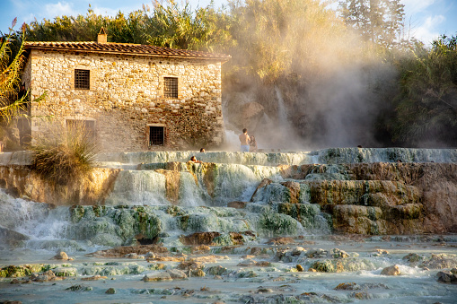 Landscape of people bathing in natural spa and waterfall
