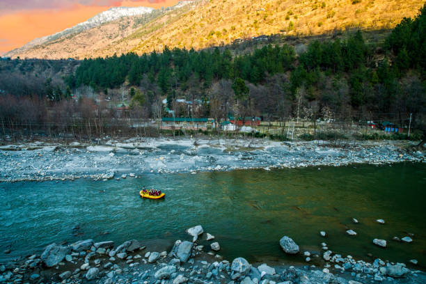Rafting : boat moving on quiet river section-river Beas . next to Kullu town in Himachal Pradesh. Really service man control boat himself , other tourists who sitting in boat for pay and making selfie. unrecognizable persons. Rafting : boat moving on quiet river section-river Beas . next to Kullu town in Himachal Pradesh. Really service man control boat himself , other tourists who sitting in boat for pay and making selfie. unrecognizable persons. several local residents are sitting in the forest kullu stock pictures, royalty-free photos & images