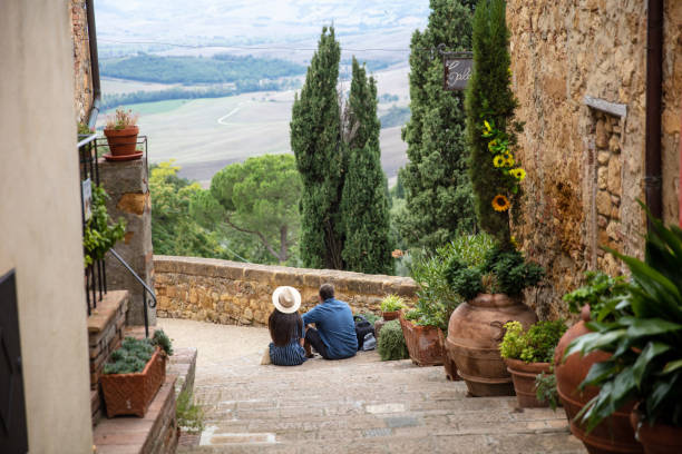 rückansicht eines paares, das auf der treppe sitzt, pienza, italien - toskana italien stock-fotos und bilder