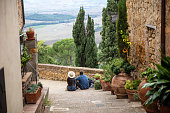Rear view of a couple sitting on the stairs, Pienza, Italy
