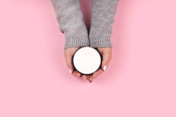 istock Hands holding jar with cream on pink background 1326120644