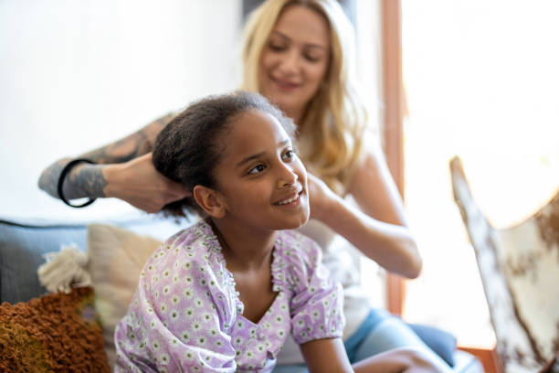 Mother combing curly hair of a daughter