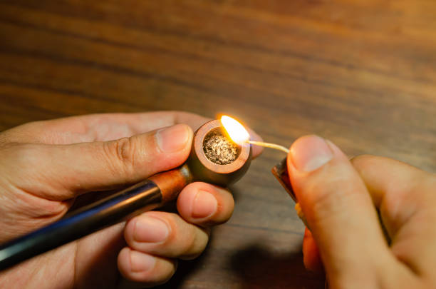 istock man lighting a tobacco pipe on a wooden table background Soft focus 1326124483