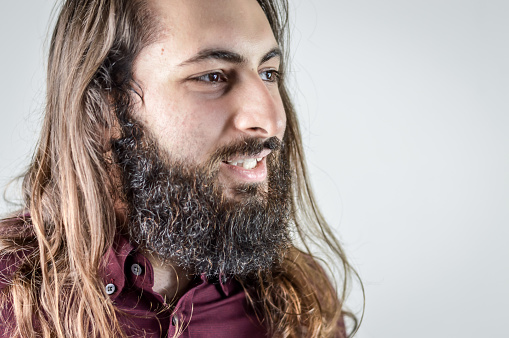 portrait of a young middle eastern businessman with beard and long hair