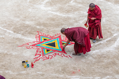 Lamayuru Gompa, Ladakh, India - june 14, 2015 : Buddhist monks paint a religious pattern in the monastery Lamayuru, Ladakh, North India