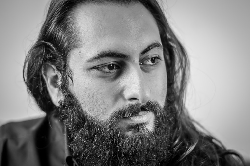 black and white portrait of a young middle eastern businessman with beard and long hair