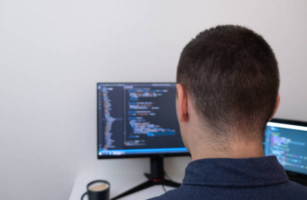 istock Male programmer working from home. The man looks at the monitor with the code. Technology and homework concept 1326132023