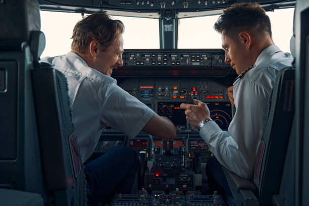 istock Cheerful pilot and a co-pilot seated in the flight deck 1326132253
