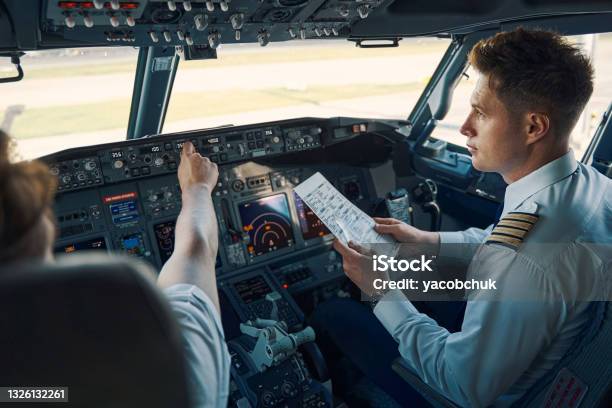 Airline Captain And First Officer Sitting In The Cockpit Stock Photo - Download Image Now