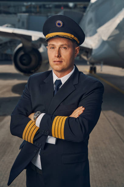 istock Aviator in uniform and a cap posing for the camera 1326132313