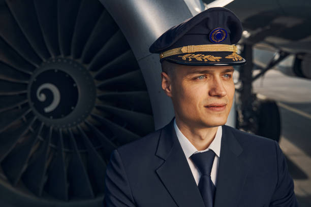 istock Serious handsome aviator standing by a turbofan engine 1326132333