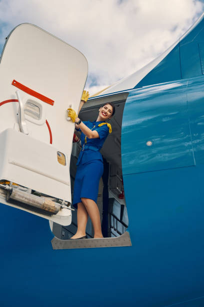istock Lovely air hostess posing for the camera before the take-off 1326132466