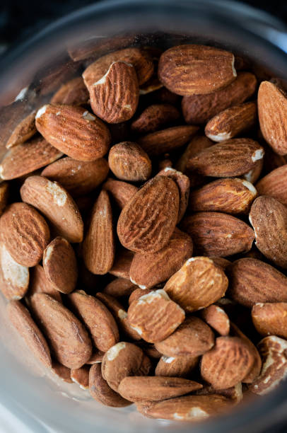 istock Almonds in a glass jar on a dark stone kitchen counter 1326136429