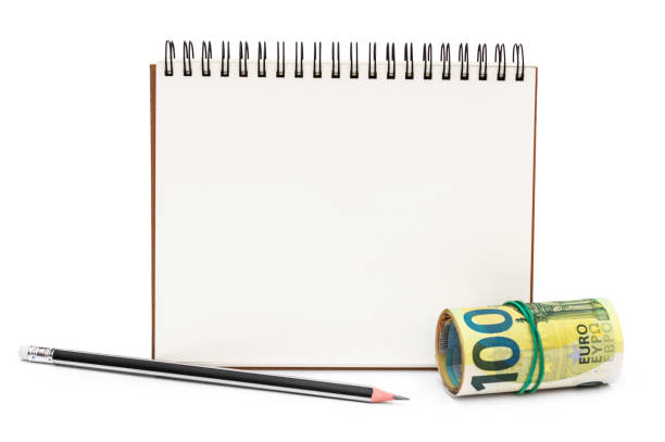 istock Blank notepad with pencil and rolled up euro bills on white background. 1326136973
