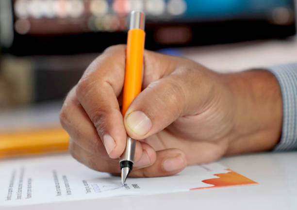 istock Signing documents with a pen making the signature sitting at the desk 1326137900