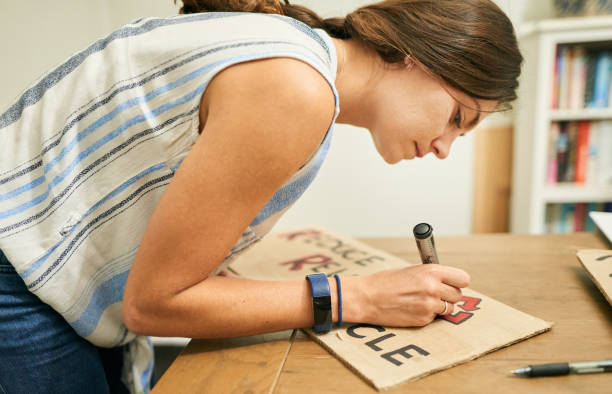 istock Young woman making a climate change protest sign at home 1326138176
