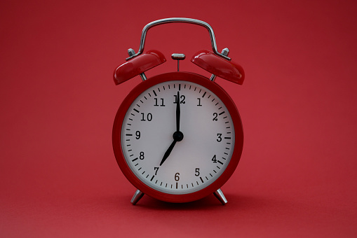 Closeup of alarm clock on red background. Time management concept