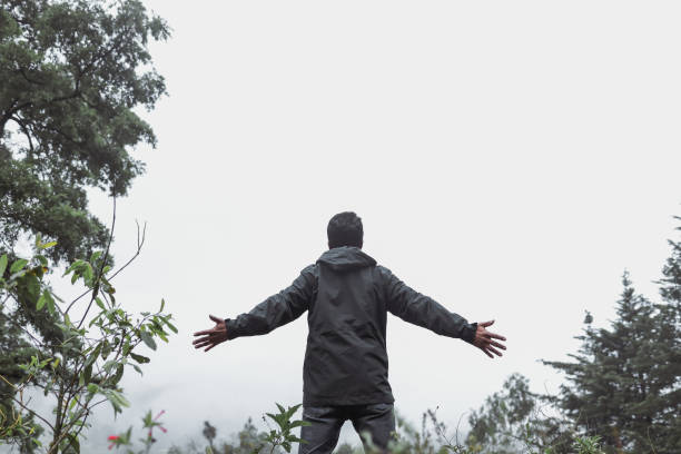 istock man on his back with his arms open in the forest with copy space 1326140667