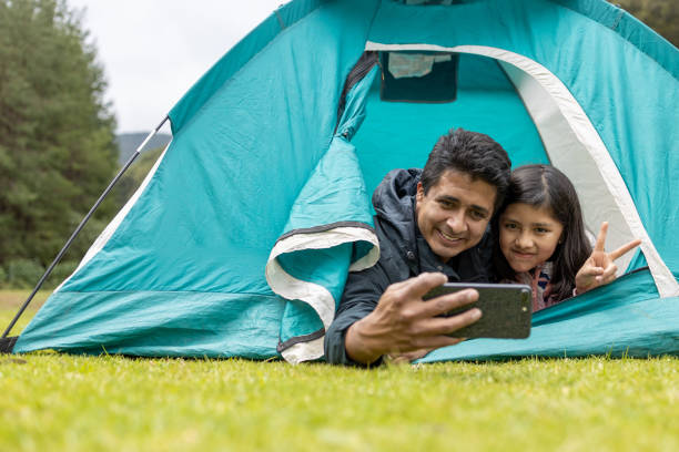 istock father and daughter taking selfie on camping tent 1326141915