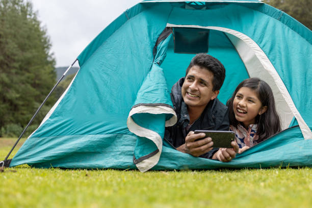 istock father and daughter taking selfie on camping tent 1326142466