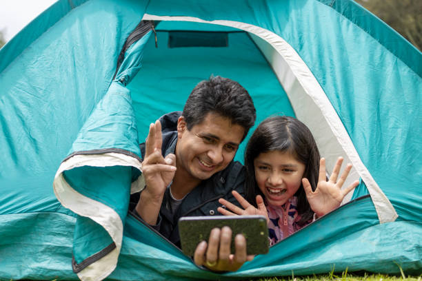 istock father and daughter taking selfie on camping tent 1326142468