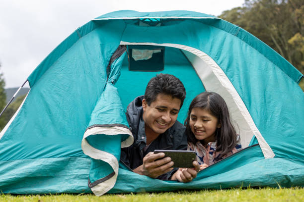 istock father and daughter taking selfie on camping tent 1326142545