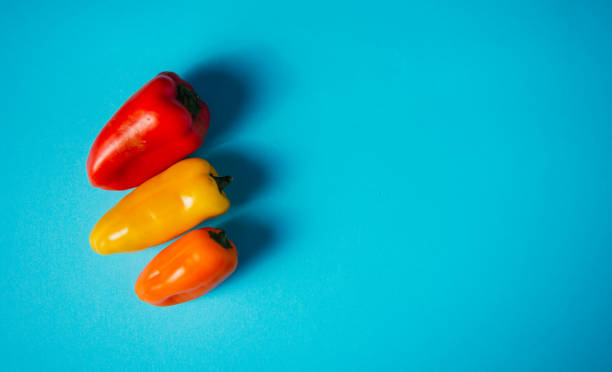 istock small peppers of various colors on a light blue background 1326144307