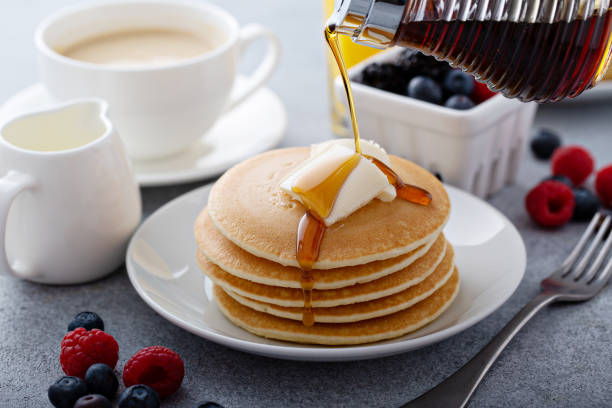 istock Stack of pancakes with butter and syrup pouring over 1326146511