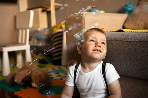 istock Cute Baby with Soap Bubbles in living room 1326148754