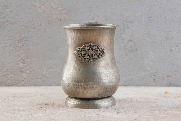 istock Antique metal cup on a concrete background. 1326149854