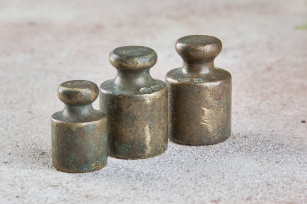 istock Three antique bronze weights for scales on concrete background. 1326149876