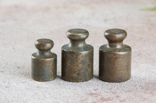 istock Three antique bronze weights for scales on concrete background. 1326149897