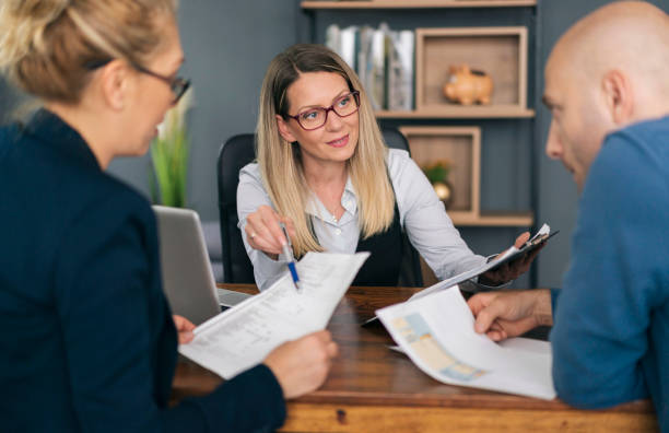 istock Financial advisor explaining paperwork to young couple 1326152650