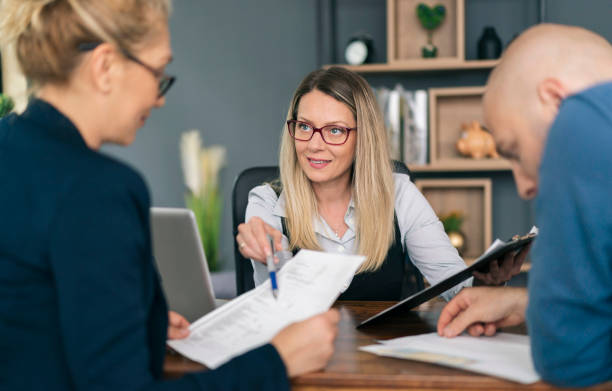 istock Financial advisor explaining paperwork to young couple 1326152656