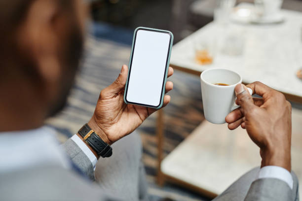 istock Businessman Holding Smartphone in Cafe Mock Up 1326153723