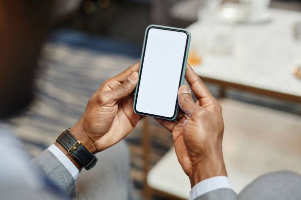 Businessman Holding Blank Smartphone Mock Up Close up of successful African-American businessman holding smartphone with blank screen, copy space businessman african descent on the phone business person stock pictures, royalty-free photos & images